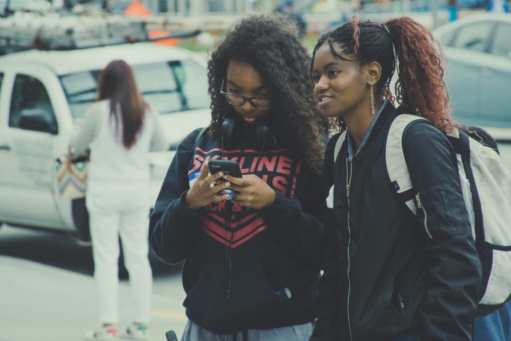 Two smiling young women outdoors, enjoying city life. Perfect for lifestyle and people-themed content.