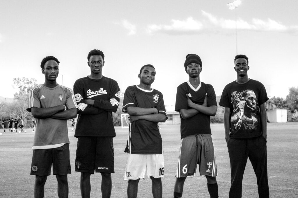 A group of young men posing confidently on a soccer field in Los Angeles, California.